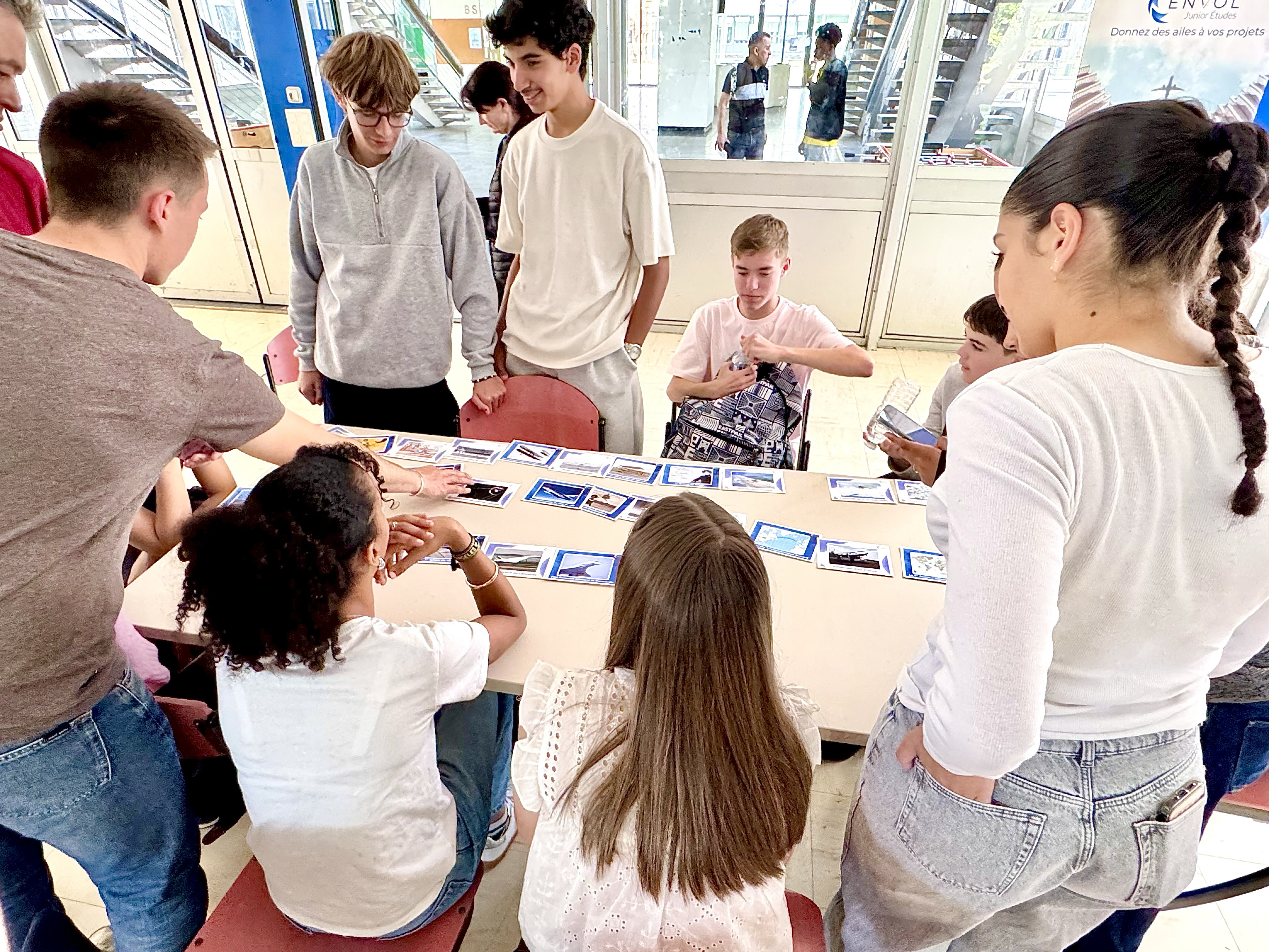 Des jeunes réunis autour d’une table disposent des cartes pour reconstituer une frise de l’histoire de l’aéronautique.
